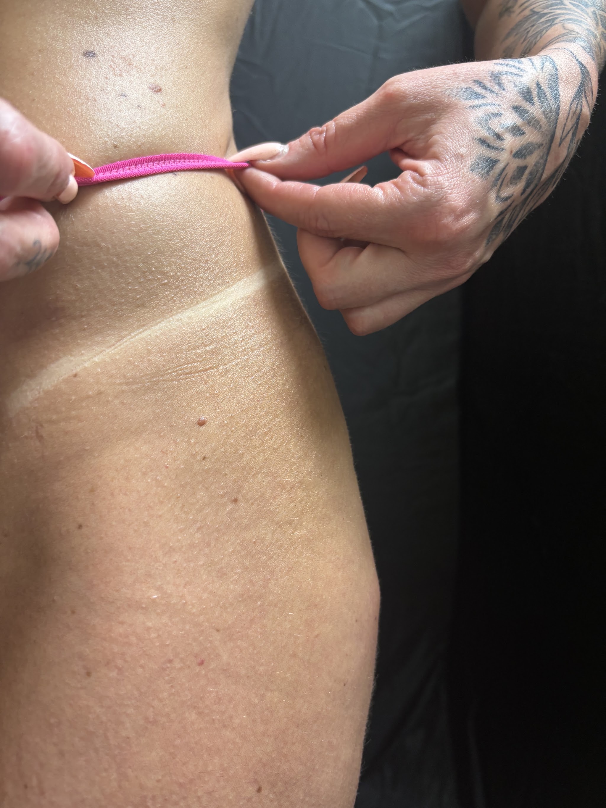 Spray tan resultaat: de tanlijn onder het opgetilde bandje